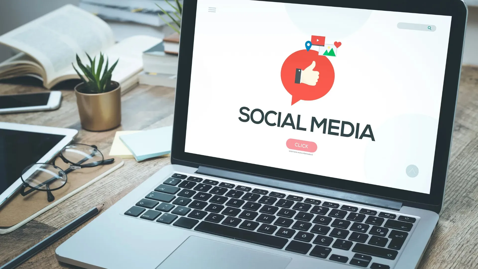 Laptop on a work desk displaying a social media marketing interface with icons for likes, location, video, and images—representing how social media marketing services in Hyderabad target local audiences through digital campaigns.